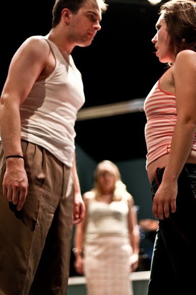 Matthew Newlin (Garcin) and Caitlin McKechney (Inez) confront each other with Estelle (Susan Nelson) in thebackground.